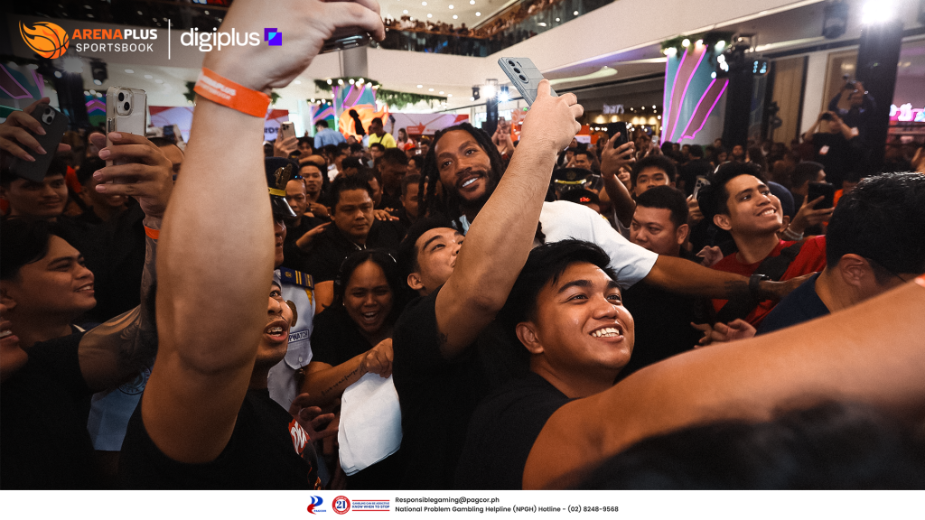 Derrick Rose surrounded by cheering fans taking photos at an ArenaPlus event in a shopping mall.